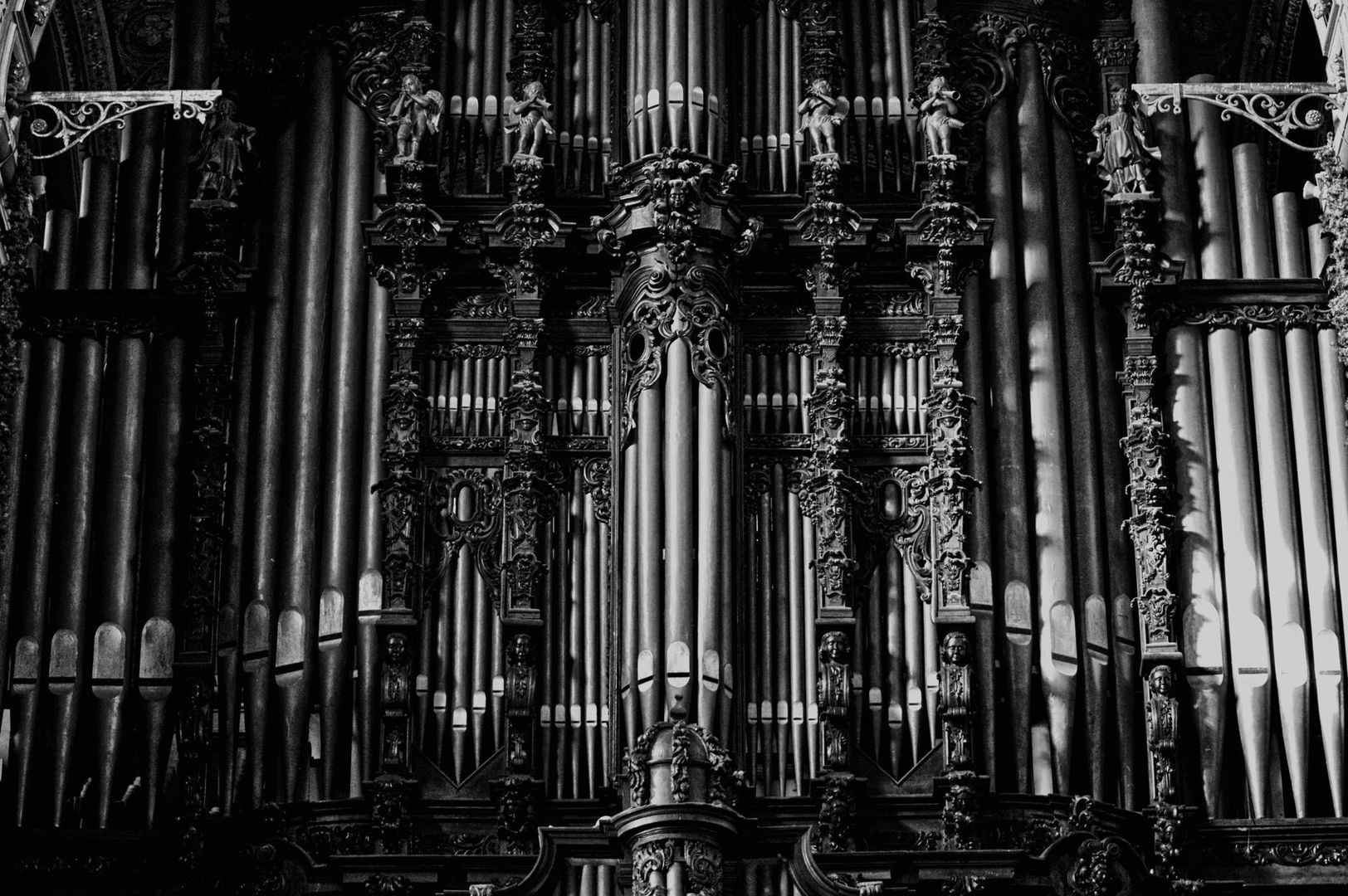 Schwarzweiße Nahaufnahme einer reich verzierten barocken Orgel
