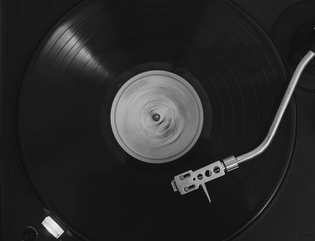 Nahaufnahme einer schwarzen Vinylplatte mit Tonarm auf einem Plattenspieler